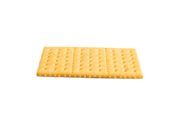 A cracker is sitting on a white background. The cracker is yellow and has a hole in the middle