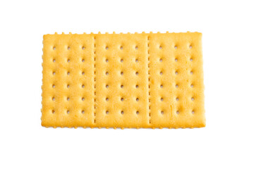 A piece of cracker with three holes in it. The cracker is yellow and has a white background