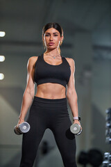 fitness enthusiast stands confidently in contemporary gym lifting dumbbells enhance strength. atmosphere is motivating and energizing gym equipment in background.
