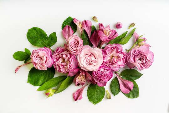 Delicate pink roses and alstroemeria with dew drops, floral flat lay on white minimal background with copy space for text