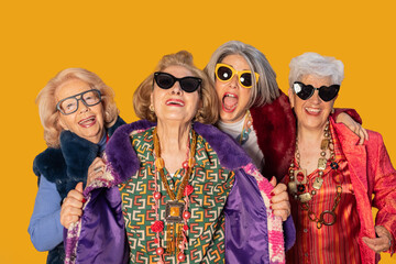 Four fashionable senior women smiling and having fun