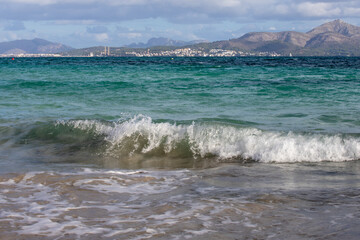 Mediterranean beach on the island of Majorca, or Mallorca on Balearic Sea, are part of Spain. Island in the Mediterranean Sea. Seaside vacations, clouds, seascape. View of the sea and the island.  