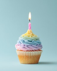 Delightful cupcake with pastel rainbow frosting and a single pink candle flickering on a light blue background creating a cheerful and festive mood perfect for celebration