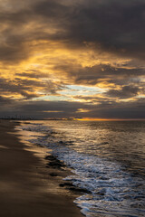 A huge storm on the coast gives a gloomy look and a clearing that allows you to see the sunset.