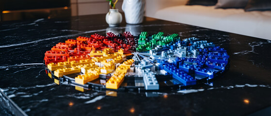 Colorful arrangement of building blocks on a dark marble surface, showcasing creativity and design.