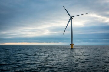 Offshore Wind Turbine Standing Tall in the Blue Ocean Under Cloudy Sky, Energy Concept