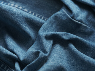 Fototapeta premium A background of blue wrinkled denim jeans. Close up.