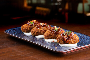 portion of mini croquettes with 4 units on parmesan cream in close-up