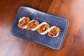 portion of mini croquettes with 4 units on parmesan cream top view