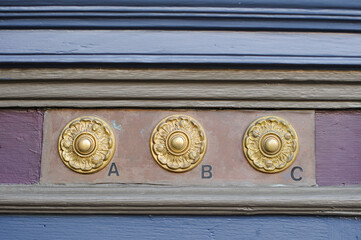 Ornate doorbells at the entryway to a brightly painted Victorian home in San Francisco, California.