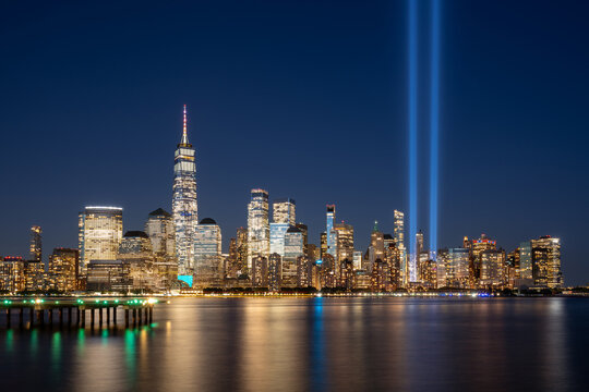 September 11 Tribute in Light at night with the World Trade Center skyscrapers of Lower Manhattan. New York City Financial District and Hudson River