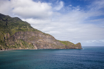 Fototapeta premium Majestic cliffs meet tranquil waters on the coast of Madeira Island, showcasing natural beauty and serenity in a breathtaking landscape