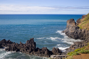 Stunning coastal view of Madeira showcasing rugged cliffs and vibrant blue ocean on a sunny day