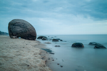 Stunning Laucu stone by the calm Baltic Sea shoreline in Latvia during a tranquil overcast day