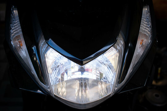 Close up of the main headlight design on an automatic scooter, showcasing the modern and angular shape of the lamp housing