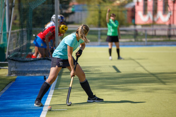Young Female Player Performing Corner Strike in Field Hockey Game