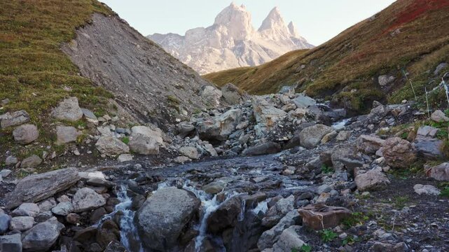 Landscape of Aiguilles d Arves of rugged rocky mountain peak and cascade flowing during autumn in Maurienne Valley at France