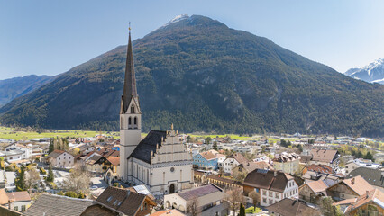 Aerial winter view of the city centre of Imst in Tirol. Beautiful city view with Tschirgant mountain in the background and Pfarrkirche Imst in foreground. Tourist travel destination in Tyrol, Austria.