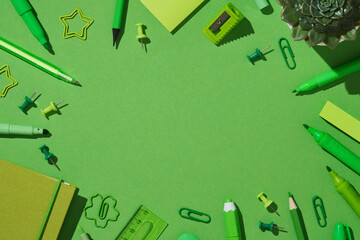 A frame of bright green stationery. Pens, pencils, markers, clipboards, pins, notepad, sharpener, sticky notes, eraser, ruler. Space for your text.