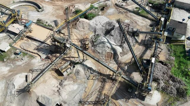 Vista a&eacute;rea de planta de minera&ccedil;&atilde;o com britadores, esteiras e escavadeiras operando na extra&ccedil;&atilde;o e processamento de areia e brita em ambiente industrial a c&eacute;u aberto