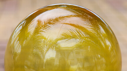 A yellow ball with a green leaf on it