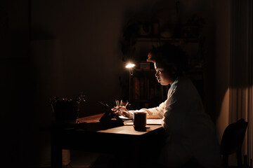 Young African businesswoman working on a tablet at her office desk late at night
