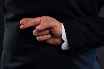 Close-up of hand with crossed fingers behind back.