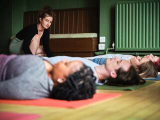 Meditation, yoga and coach in savasana pose at gym, relax or peace in mindfulness class. Zen,...