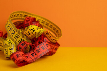 Multicolored measuring tapes on background. Tool for measuring length and volume. Tape for...