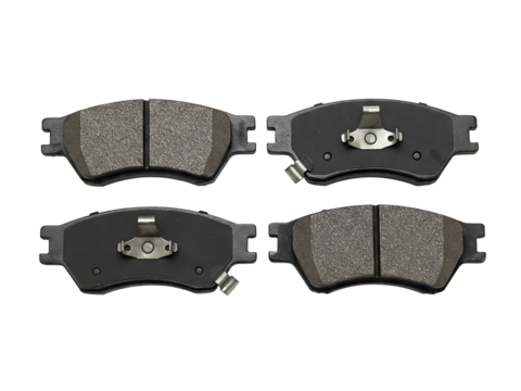 Set of Four Automotive Brake Pads (Top-Down): A top-down view of a set of four automotive brake pads with ceramic friction material and metal backing plates, set on a transparent surface.