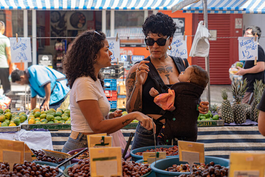 Candid moment of LGBTQ+ couple with baby shopping at street market in S&atilde;o Paulo
