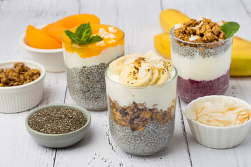 Assortment of chia puddings in cups with different fruit flavors on plant milk. Horizontal, Lactose-free desserts, vegan, healthy food