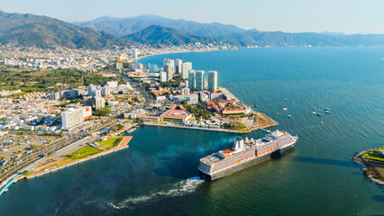 Obraz premium Huge cruise ship dominating the city skyline at sunset. Puerto Vallarta, Jalisco. Mexico