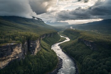 Aerial photograph of a winding river cutting through a lush, green valley, surrounded by steep cliffs and dense forest. 