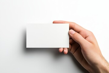 Obraz premium Hand holding a blank card against a clean white background for promotional or creative purposes