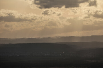 View of mountains in golden sunlight and a town located in a valley. Beautiful mountain landscape
