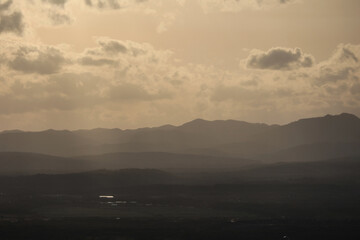View of mountains in golden sunlight and a town located in a valley. Beautiful mountain landscape