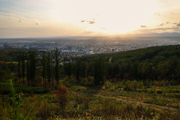 Panoramic view from the mountain to the city located in the valley and the forest. Beautiful cityscape of Sakhalin in golden sunlight