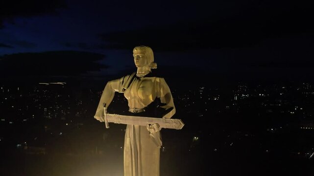 Yerevan, Armenia &ndash; April 16, 2025: Aerial night view of the Mother Armenia statue illuminated in Victory Park against the backdrop of the city lights.