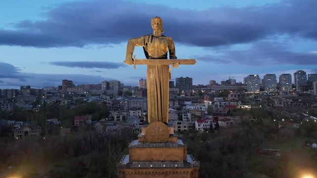 Yerevan, Armenia &ndash; April 16, 2025: Aerial night view of the Mother Armenia statue illuminated in Victory Park against the backdrop of the city lights.