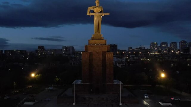 Yerevan, Armenia &ndash; April 16, 2025: Aerial night view of the Mother Armenia statue illuminated in Victory Park against the backdrop of the city lights.