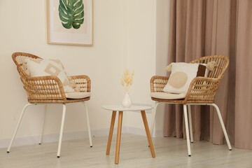 Fototapeta premium Living room with pastel window curtain, wooden table and rattan chairs