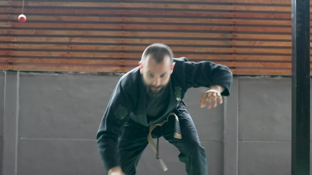 Martial arts master practicing self-defense techniques in a gym