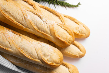 Baguette recién horneada sobre una superficie de madera, con su corteza dorada y crujiente. Imagen que transmite frescura y un toque artesanal, ideal para la cocina y productos de panadería.
