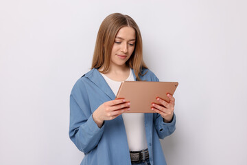 Fototapeta premium Beautiful teenage girl with tablet on white background