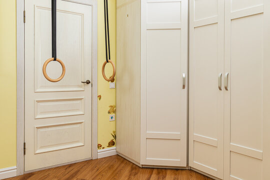 Home gym setup with rings in a yellow room