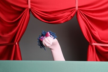 Creative puppet show on stage with red curtains