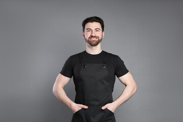 Naklejka premium Portrait of smiling barista on grey background