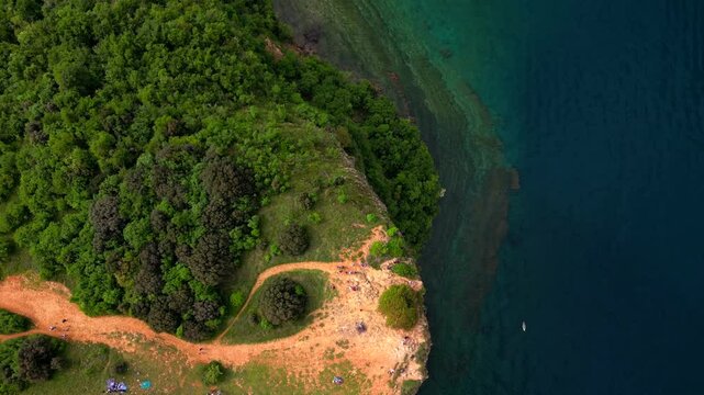Aerial view of Rocca di Manerba with the cliff overlooking Lake Garda in the province of Brescia, Lombardy, Italy. The video expresses serenity and peace while waiting for the summer season 
