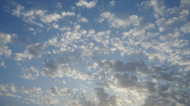 Real time video with altocumulus high cumulus heaped cloud stratocumuliform. Globular masses or rolls in patches. Cumuliform stratocumuliform clouds altocumulus signifies convection. Blue evening sky